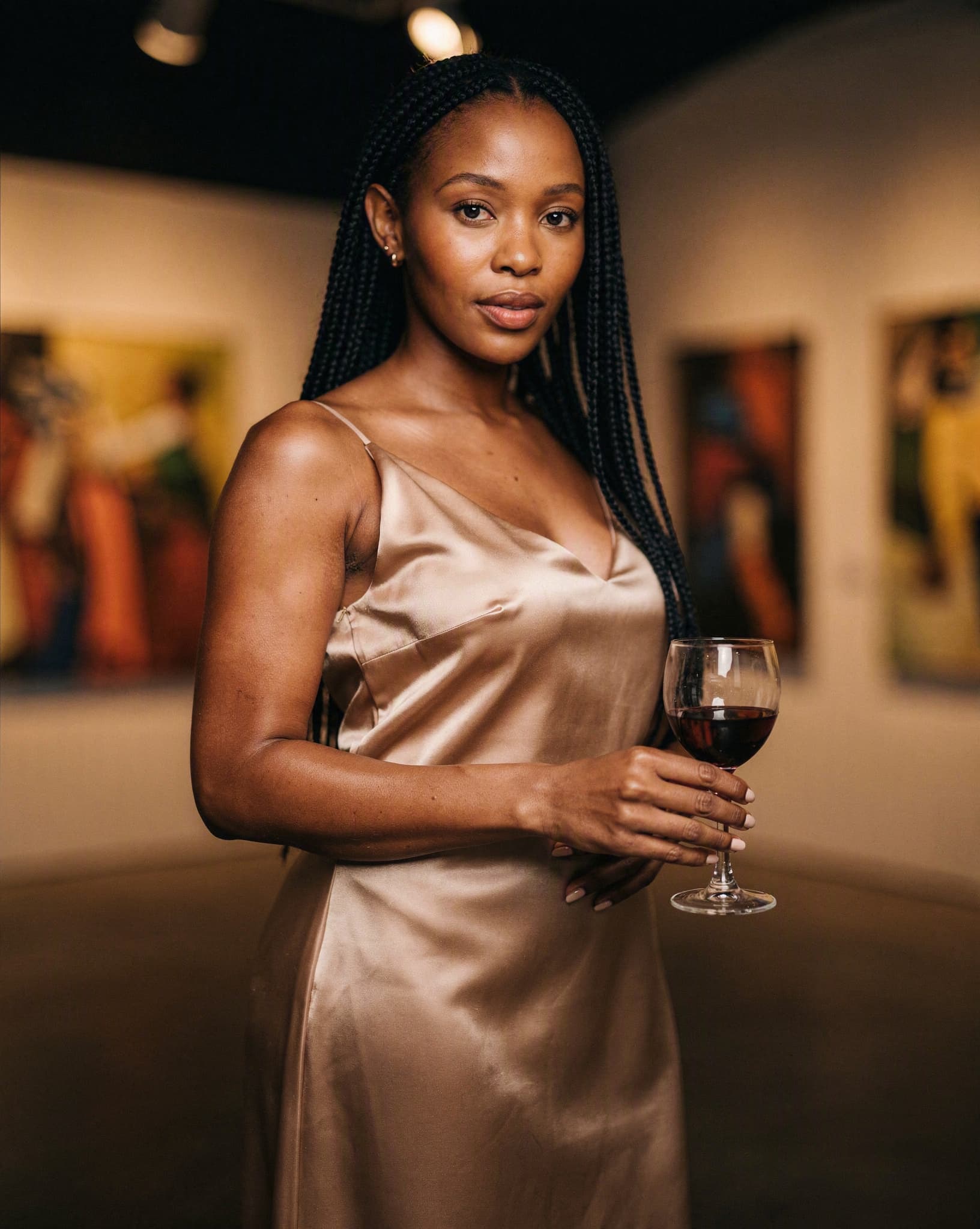 Author Tracy Nxumalo in a champagne slip gown at an art gallery